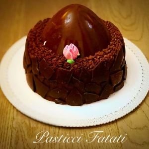 dolce rivestito con pezzi di cioccolato e copertura con uovo di cioccolato