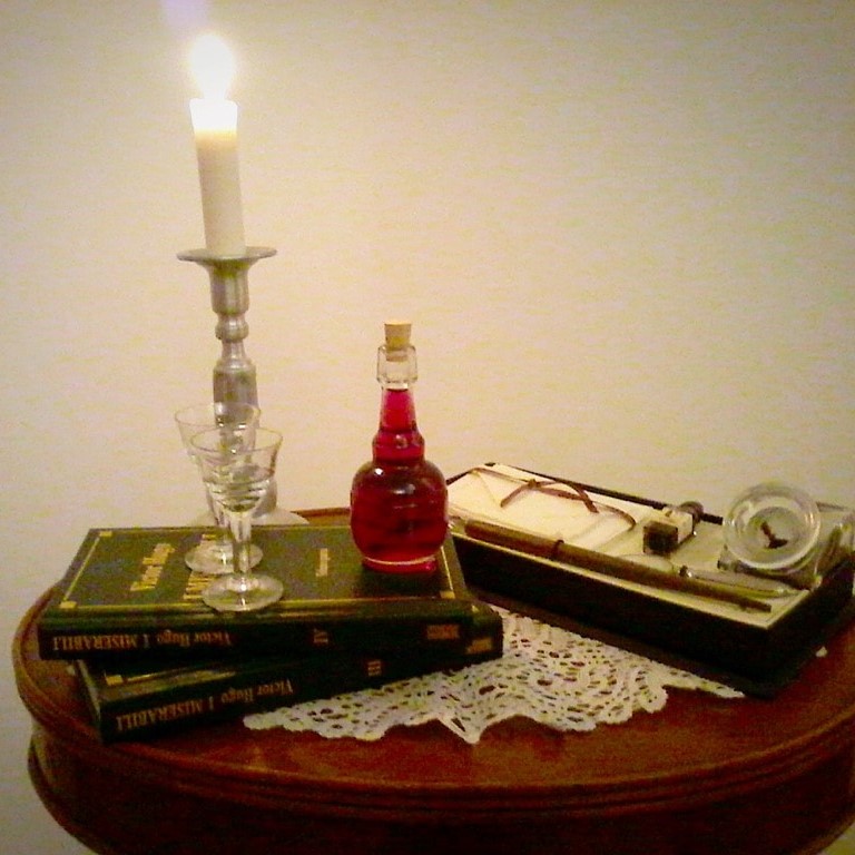 Liquore all'uva americana, ambientazione retrò con libri, calamaio e candelabro