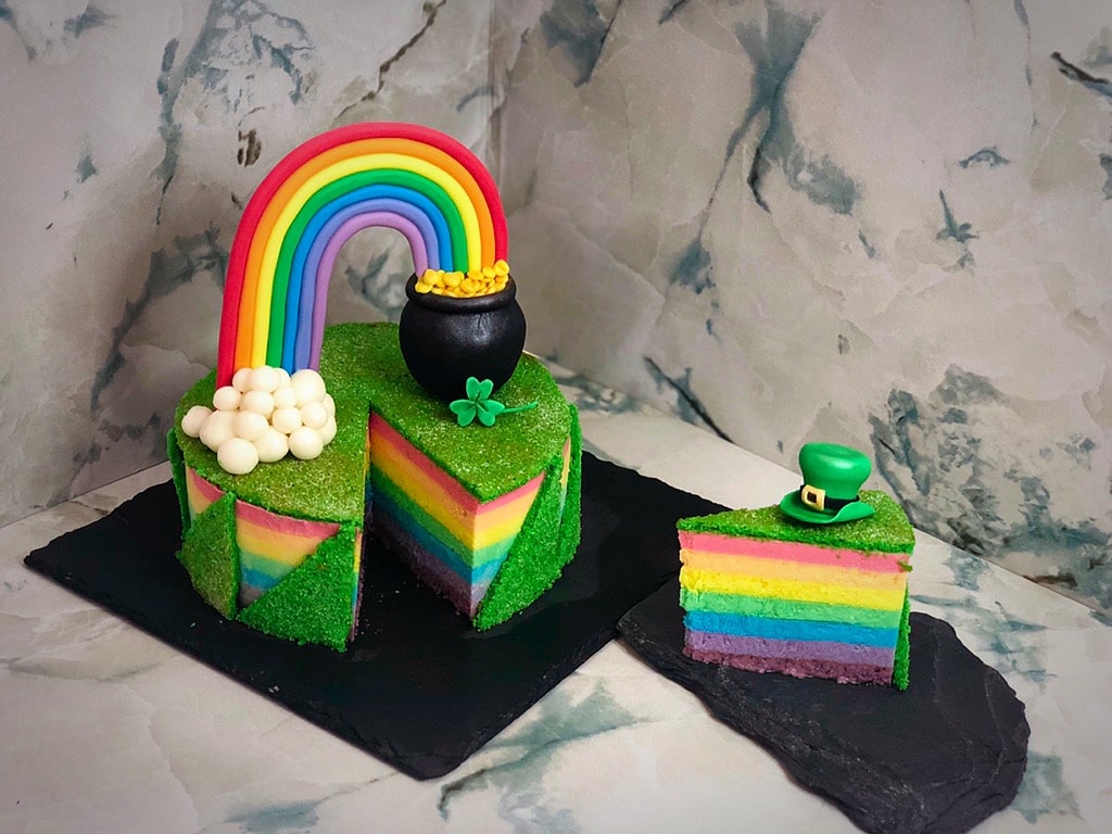 rainbow fresh cake decorata con pentola d'oro alla fine dell'arcobaleno, fetta tagliata per vedere interno