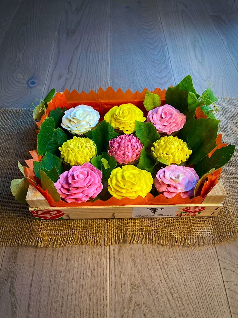 cassetta con vasetti di fiori realizzati con dei cupcakes, rose e crisantemi