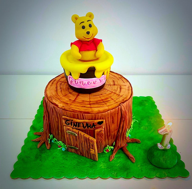 Winnie the Pooh in un vasetto di miele su un tronco